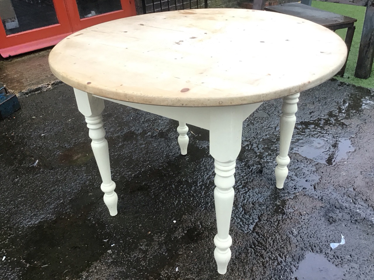 A pine kitchen table with circular top on a painted square base raised on turned tapering legs. ( - Image 3 of 3