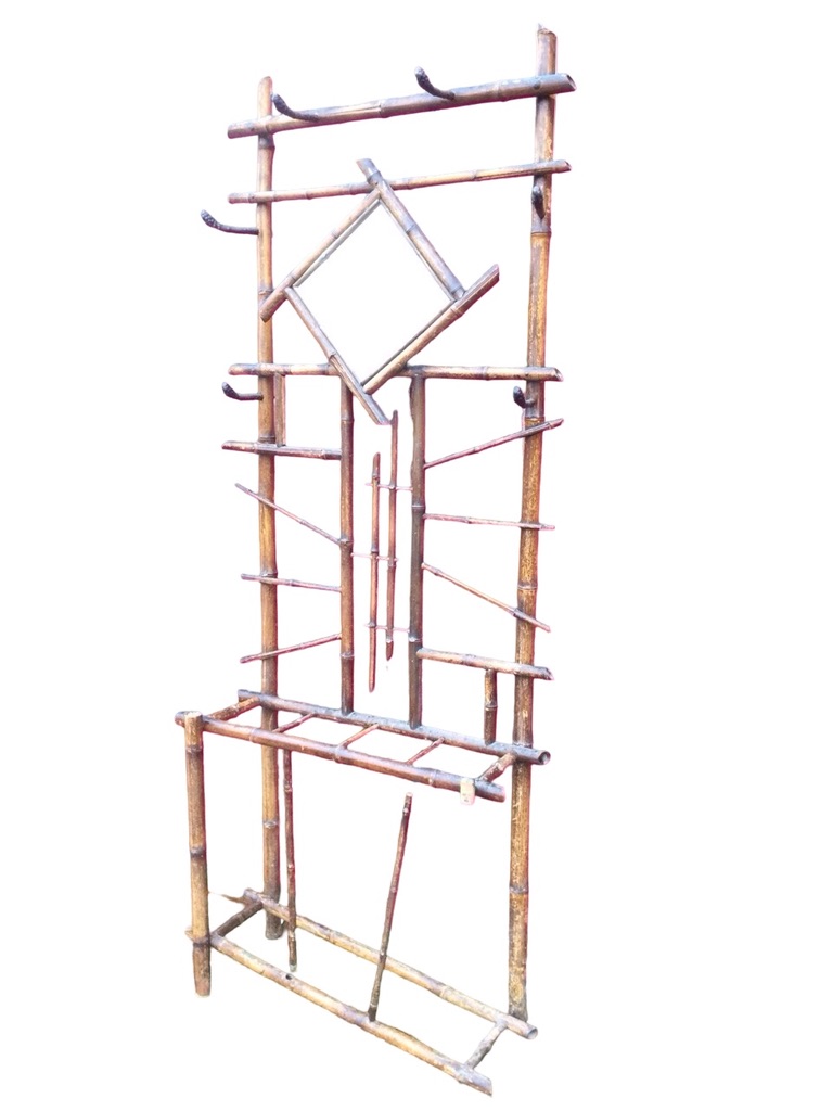 An Edwardian bamboo hallstand, the back mounted with six iron pegs and framed mirror, the base