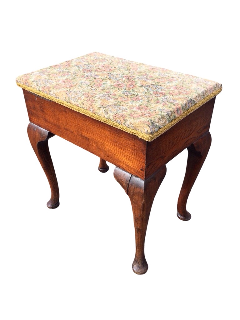 A rectangular oak stool with box seat having upholstered hinged lid, raised on cabriole legs with
