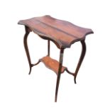An Edwardian mahogany occasional table with serpentine moulded top above a shaped apron, raised on