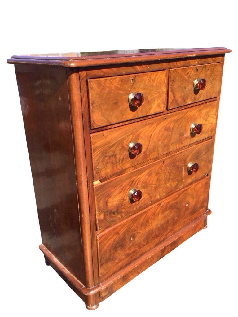 A Victorian mahogany chest of drawers with rounded moulded top above two short and three long