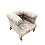 A Victorian upholstered armchair with outscrolled back and arms above a square seat, raised on