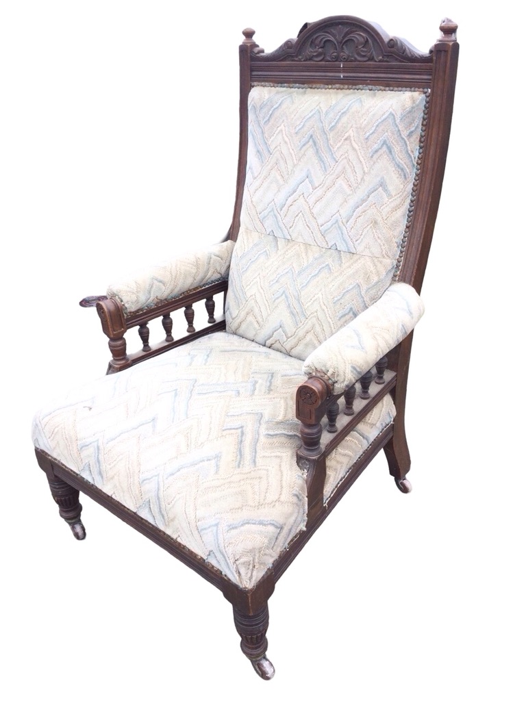 An Edwardian mahogany armchair, the foliate carved back with turned finials above an upholstered