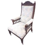 An Edwardian mahogany armchair, the foliate carved back with turned finials above an upholstered