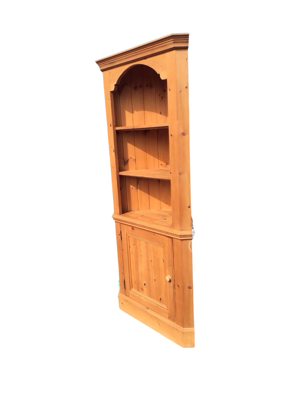A Victorian style pine corner cabinet with moulded cornice above open shelves and a knobbed