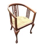 An Edwardian mahogany armchair with horseshoe shaped back and arms on pierced & slatted splats,