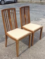 A pair of Edwardian mahogany chairs with rectangular boxwood strung slatted backs and floral