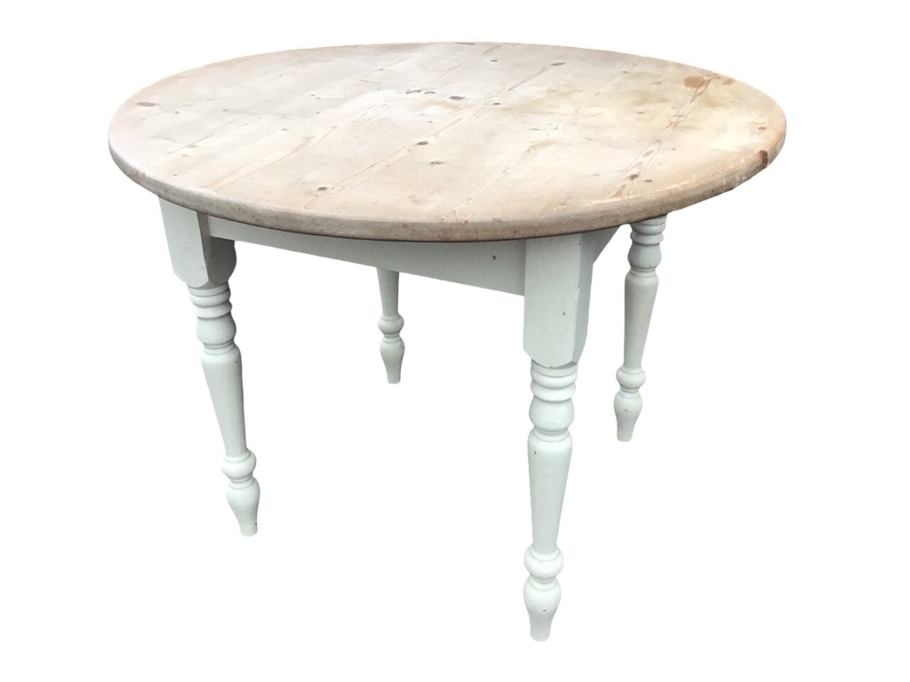 A pine kitchen table with circular top on a painted square base raised on turned tapering legs. (