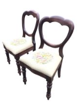 A pair of Victorian mahogany balloon-back chairs with drop-in upholstered seats, raised on turned