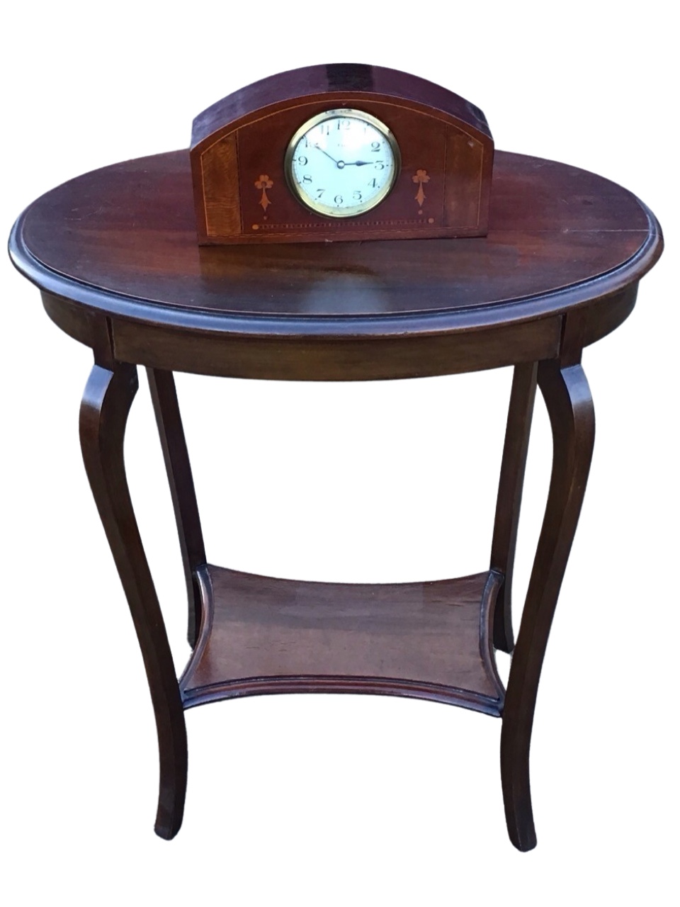 An Edwardian mahogany occasional table with oval moulded top above a plain apron, raised on square