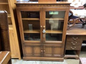 Ercol-style elm bookcase with two glazed doors and two panelled doors below 138cm high, 101cm wide,