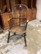 Early 19th century Windsor elm stick back elbow chair with shaped seat on turned legs joined by crin