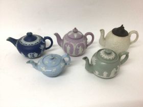 A group of five 19th century English teapots, including one dark blue Wedgwood jasperware, one lilac