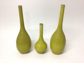Three graduated 19th century Chinese/Japanese yellow monochrome crackle-glazed bottle vases, 25cm to