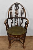 Gothic style mahogany revolving desk chair, with arched tracery back and circular saddle seat on cab