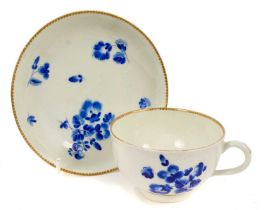 Worcester dry blue enamel cup and saucer, circa 1770, decorated with floral sprays, with gilt dentil