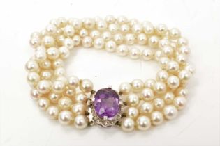 Cultured pearl four strand bracelet with an amethyst and diamond set oval clasp