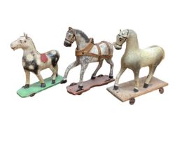 Three 19th century child's carved horses on wheeled bases