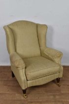 Laura Ashley wing armchair, raised on fluted legs and castors