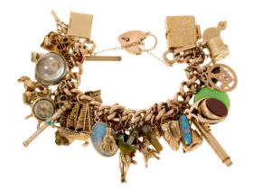 Antique gold charm bracelet with a collection of antique and vintage gold and gilt metal charms to i