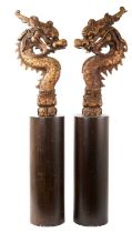 Pair of Oriental carved wood dragon heads raised on plinths