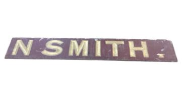 Wooden shop sign painted with hand gilt lettering spelling the name N Smith