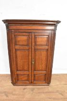 George III oak hanging corner cupboard with panelled doors