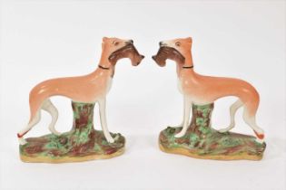 Pair of Staffordshire pottery models of standing greyhounds