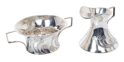 Edwardian Art Nouveau silver milk jug and sugar bowl, each with stylised floral decoration,