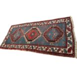 Small Caucasian rug, having three serated medallions on powered blue ground, 198 x 91cm