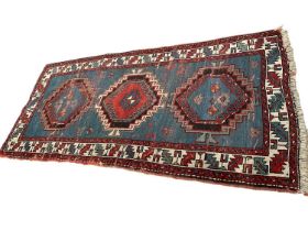 Small Caucasian rug, having three serated medallions on powered blue ground, 198 x 91cm