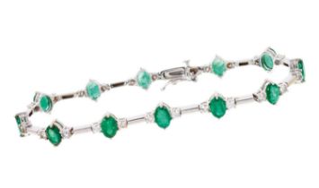 Emerald and diamond bracelet with a line of twelve oval mixed cut emeralds, each flanked by two bril