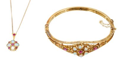 Victorian style ruby and opal hinged bangle with a floral cluster and filigree design, in 9ct gold s
