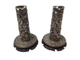Pair of Chinese white metal candlesticks with pierced dragon decoration on carved wood bases