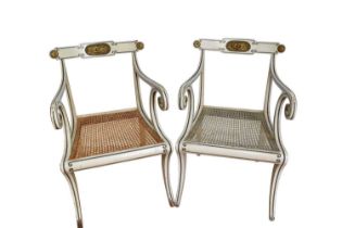 Pair of Regency style white painted and parcel gilt open elbow chairs with cane seats on sabre legs