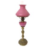 19th century peg lamp with pink glass shade and reservoir on ormolu candlestick base