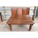 Very large Edwardian mahogany extending dining table, with three additional leaves