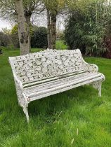 Victorian style white painted cast metal garden bench with lily pad and foliate design, 131cm wide.
