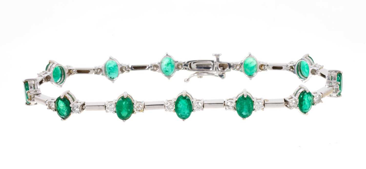 Emerald and diamond bracelet with a line of twelve oval mixed cut emeralds, each flanked by two bril - Image 2 of 3