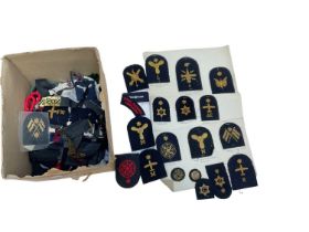Collection of various British military cloth badges to include rank insignia and Royal Navy cap tall