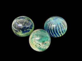 Selection of coloured glass including three Mdina paperweights