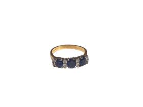 Sapphire and diamond ring with three oval mixed cut blue sapphires interspaced by eight brilliant cu