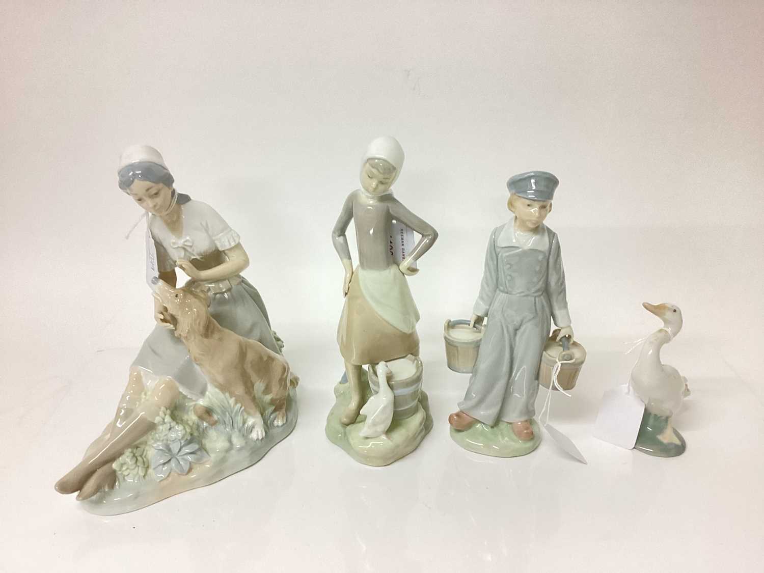 Two Lladro porcelain figures, Lladro goose and a Nao figure of a lady with dog (4)