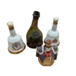 Three commemorative Bell's whisky decanters (full) and an old Armagnac bottle