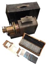 Vintage magic lantern in case together with a box of glass slides depicting mostly landscape and sea
