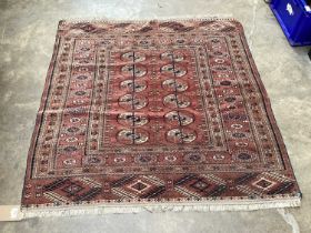 Eastern rug with geometric decoration on red ground, 115cm x 116cm