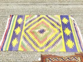Kilim rug with geometric decoration on blue, yellow, green and red ground, 157cm x 90cm, together wi