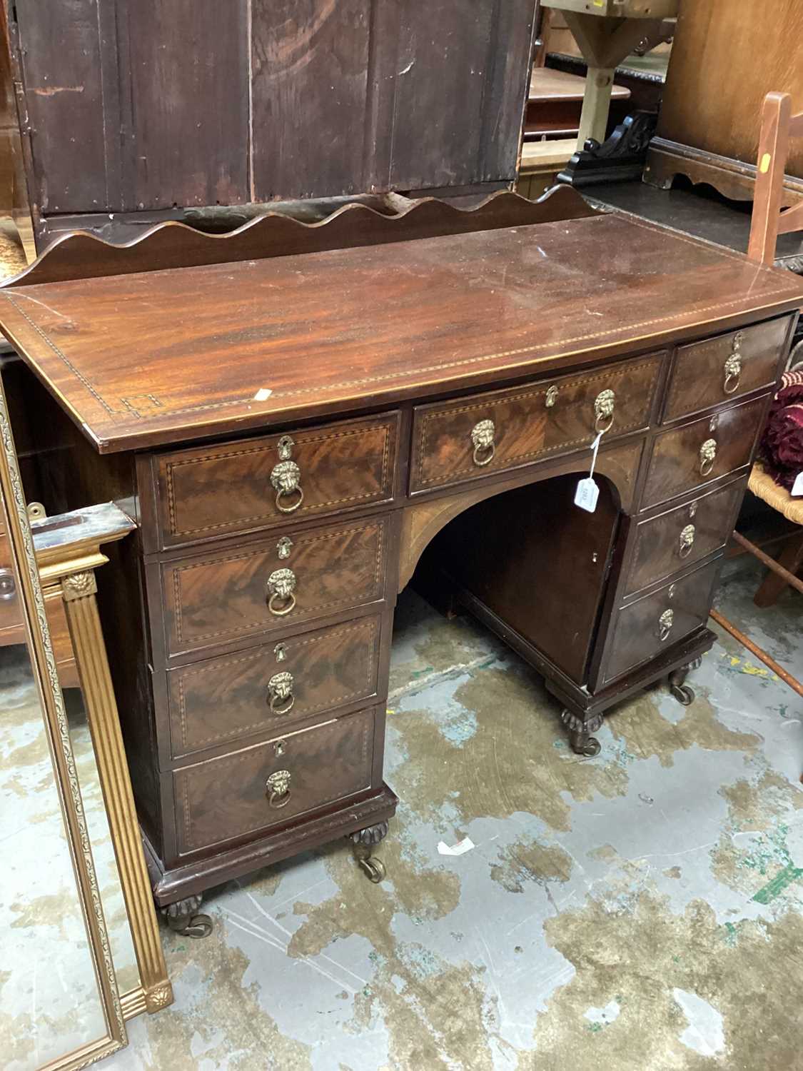 Edwardian inlaid mahogany bowfront kneehole desk with seven drawers and on cupboard below, 112cm wid