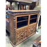 Late Victorian heavily carved oak bookcase with two glazed doors and two geometric panelled doors be