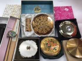 Collection of vintage compacts and accessories within a vanity case